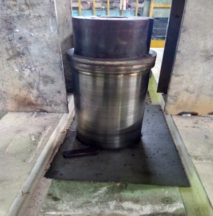 Worn shaft of thrust roller showing signs of wear due to misalignment, impacting the stability and performance of the rotary kiln.
