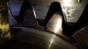 Worn girth gear and pinion showing signs of excessive wear, caused by misalignment and improper maintenance.